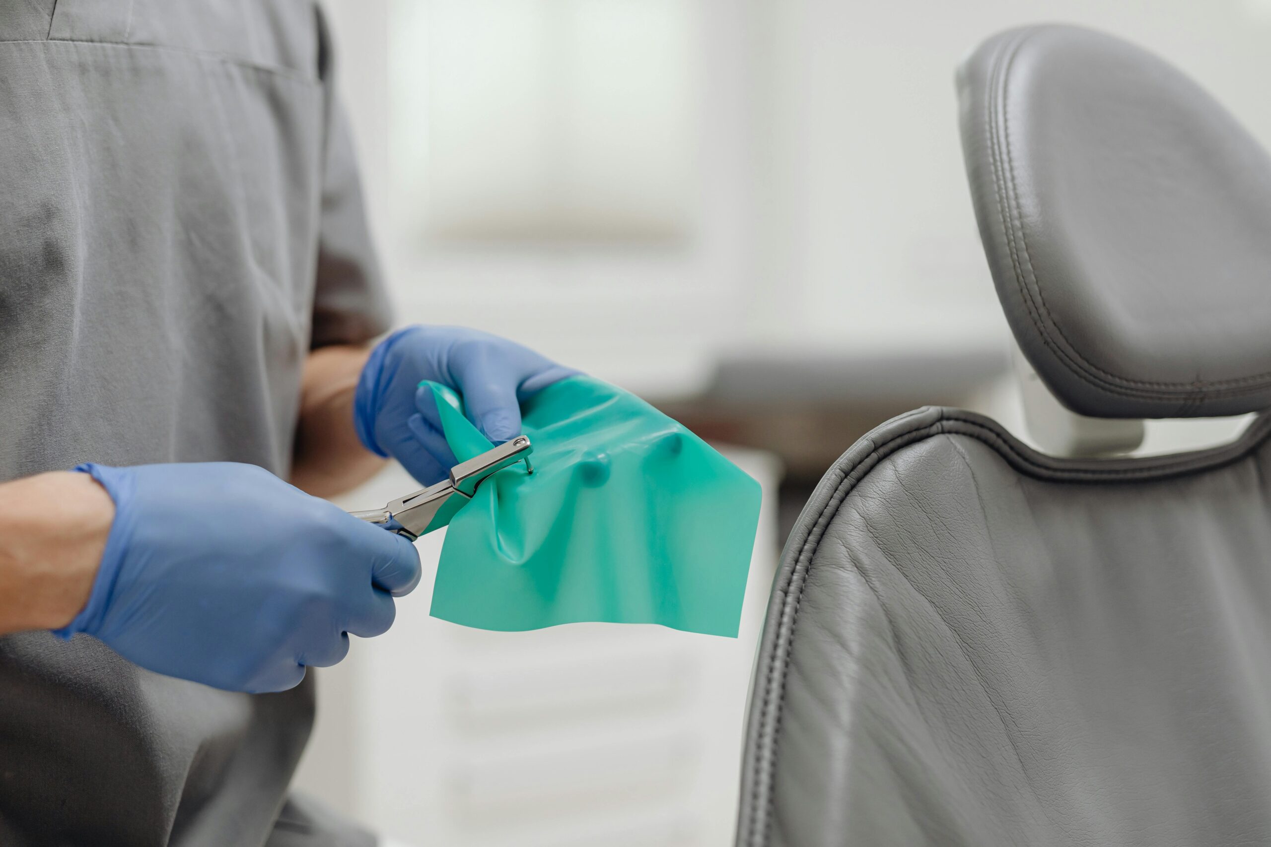 Close-up of a dentist in gloves preparing sterile dental tools in a modern clinic.